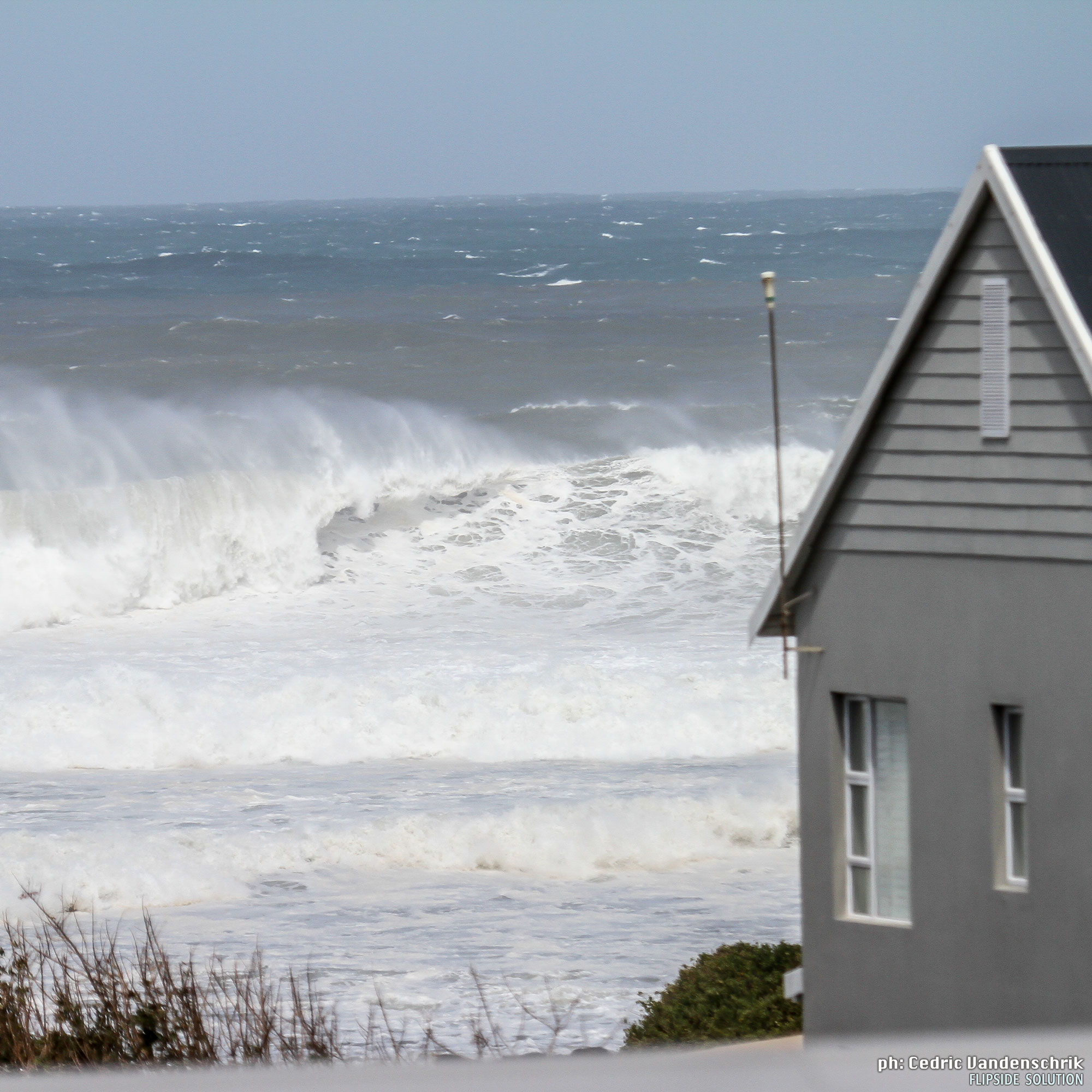 Stormy ocean waves with house